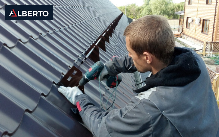 Workers installing a 26 gauge metal roof on a commercial building.